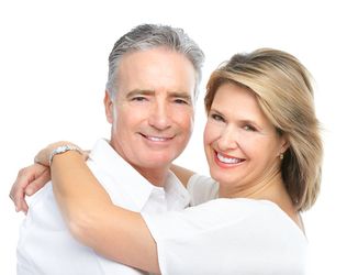 Senior couple smiling in front of coastal landscape